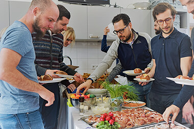 Mitarbeiter der itelio GmbH bei einem hausinternen Frühstück, das immer wieder zu besonderen Anlässen organisiert wird.