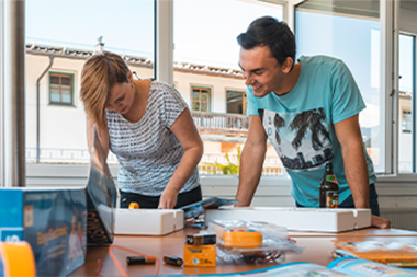 Zwei Auszubildende mit einem Technik-Bausatz in der itelio-Firmenzentrale.
